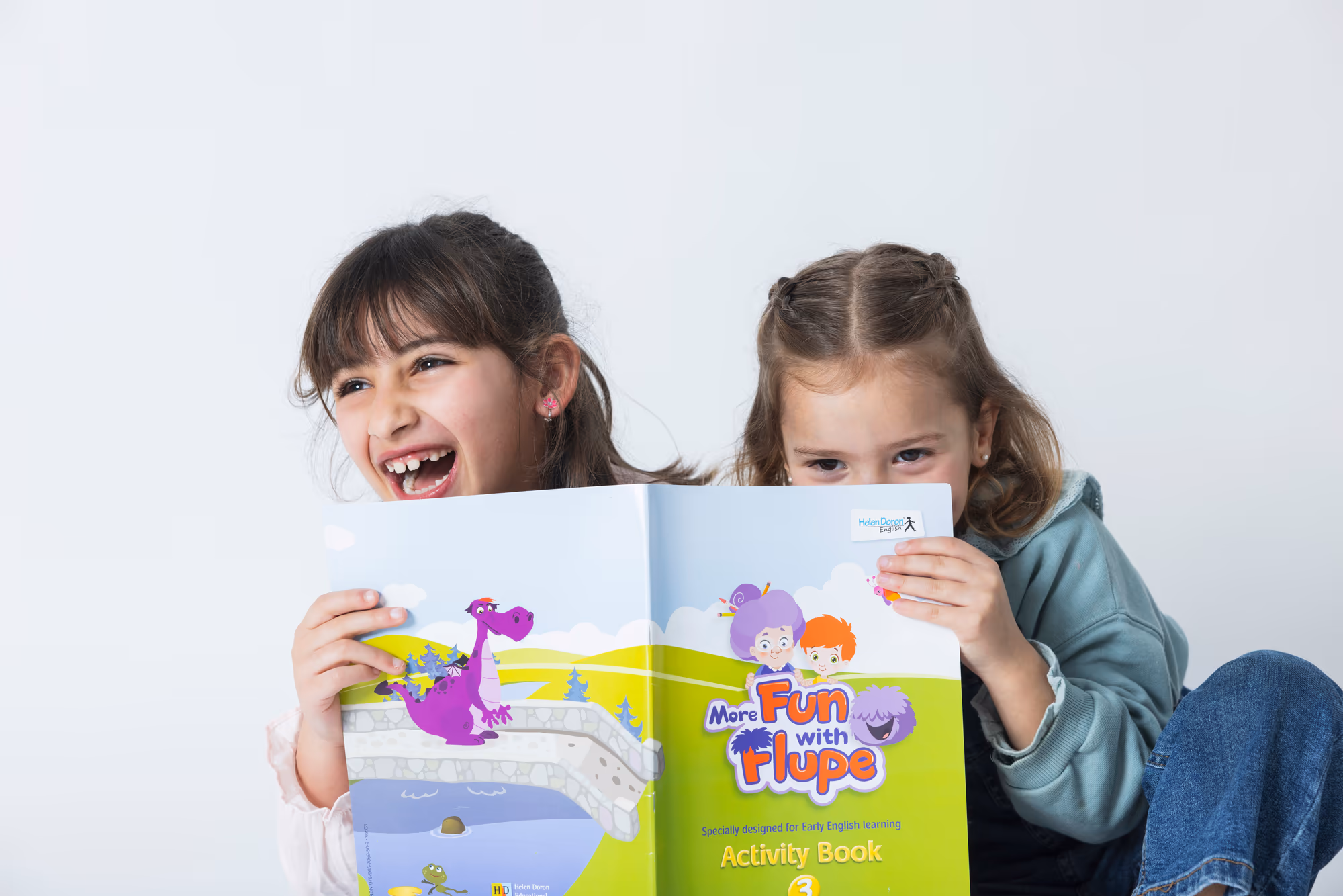 Kaks tüdrukut vaatavad koos Fun with Flupe tööraamatut